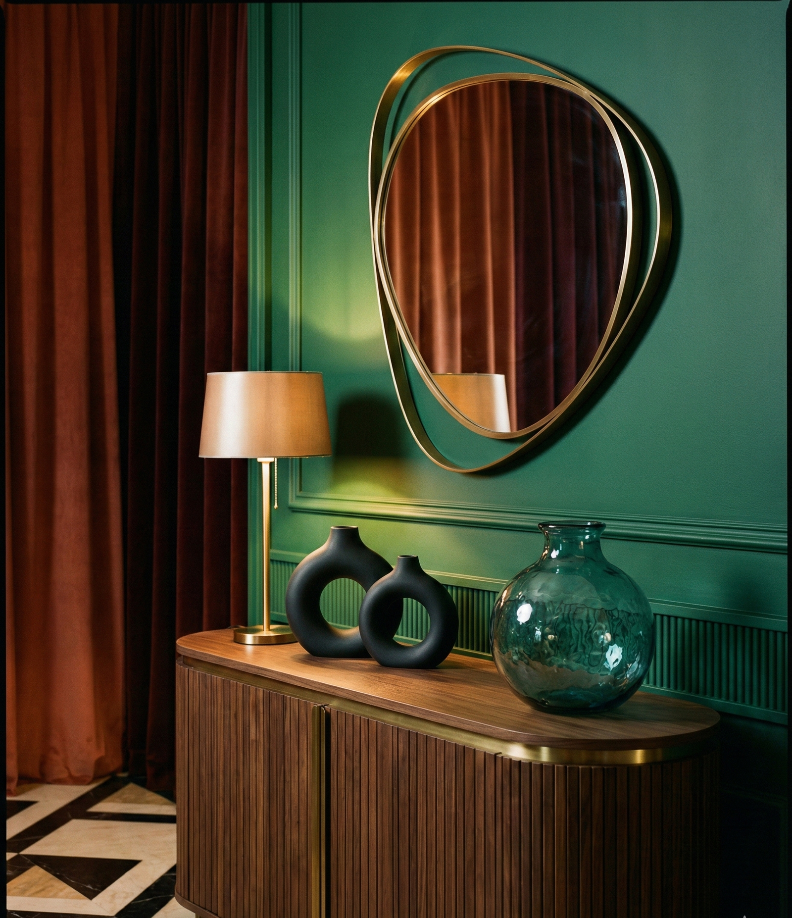 Best Art Deco Furniture & Decor Picks for a Glam 1920s Home (Checklist + What to Avoid) 1 Art deco furniture styling with an asymmetrical brass mirror, warm table lamp, black sculptural vases, and a teal glass vase on a ribbed wood console.